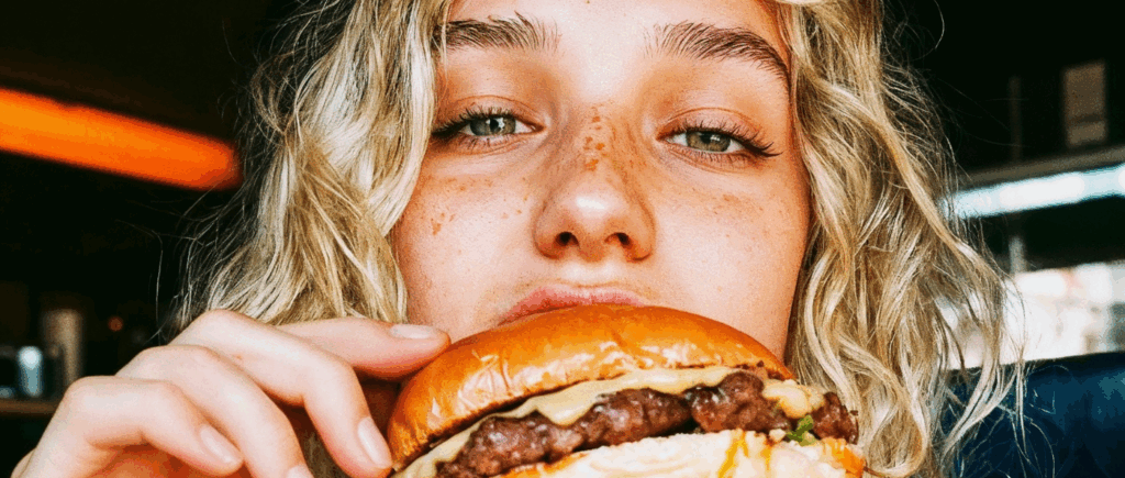 Joven chica comiéndose una hamburguesa
